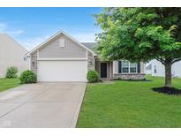 Charming home featuring a two-car garage, well-maintained lawn, and mature tree, enhancing curb appeal at 11521 Short Iron Ln, Indianapolis, IN 46235