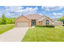 Charming brick home featuring an attached two-car garage, lush landscaping, and a well-maintained lawn at 1324 N Stewart Rd, Anderson, IN 46012