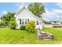 Charming white bungalow with a quaint front yard and concrete steps to the front door at 2009 S L St, Elwood, IN 46036