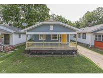 Charming home featuring a welcoming front porch with a bright yellow door and a well-maintained lawn at 2945 N Denny St, Indianapolis, IN 46218