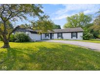 Charming single-story home featuring a white brick exterior, black shutters, an attached garage, and a well-maintained front yard at 3141 Citadel Ct, Indianapolis, IN 46268