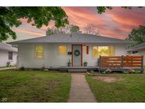Charming one-story home featuring a landscaped yard, a cozy front porch, and inviting curb appeal at sunset at 4747 Wellington Ave, Lawrence, IN 46226