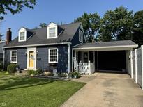 Charming home featuring a yellow front door, dormer windows, well-manicured lawn and attached carport at 537 N 17Th St, Noblesville, IN 46060