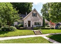 Charming brick home with professionally landscaped front yard and mature trees at 5681 Carrollton Ave, Indianapolis, IN 46220