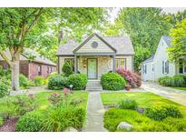 Charming home featuring a stone facade, manicured lawn, mature trees and beautiful landscaping at 6045 Haverford Ave, Indianapolis, IN 46220