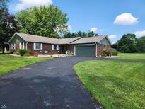 Charming single-story brick home featuring a long driveway and attached garage at 7870 E County Road 150 S, Avon, IN 46123
