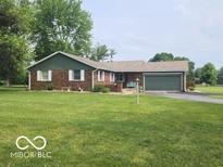 Charming brick ranch home with well-manicured front lawn, mature trees, and an attached two-car garage at 7870 E County Road 150 S, Avon, IN 46123