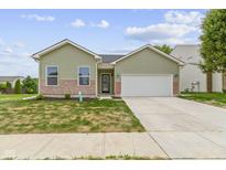 Charming single-story home featuring a two-car garage, well-maintained lawn, and brick accents at 8355 Fieldfare Way, Indianapolis, IN 46237
