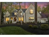 Stunning brick home with professional landscaping, elegant porch, and warm lighting at 9399 Irishmans Run Ln, Zionsville, IN 46077