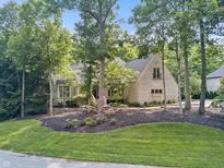 Charming brick home with a landscaped yard featuring mature trees and lush greenery at 9399 Irishmans Run Ln, Zionsville, IN 46077
