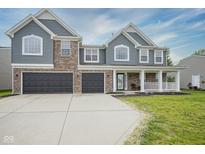 Charming two-story home featuring gray siding, brick accents, a welcoming front porch, and a two-car garage at 10903 Greenleaf Dr, Indianapolis, IN 46229