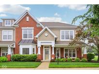 Charming townhome showcases a mix of brick and siding, complemented by a well-manicured lawn and inviting front porch at 15528 Bowie Dr, Westfield, IN 46074