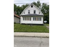 A white house with a front porch and green lawn shows the property's curb appeal at 1630 E 18Th St, Indianapolis, IN 46218