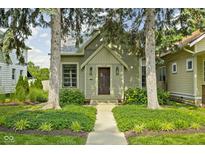 Charming home with mature trees and landscaped front yard and a pathway leading to the front door at 2158 S Garfield Dr, Indianapolis, IN 46203