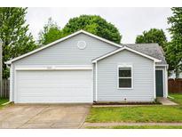 Charming single-story home featuring a one-car garage, light gray siding, and lush landscaping at 2434 Harvest Moon Dr, Greenwood, IN 46143