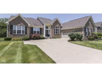 Charming brick home featuring an attached garage, lush landscaping, and an inviting curb appeal at 2502 Colinbrook Pkwy, Greenwood, IN 46143