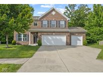 Charming two-story brick home with a three-car garage and manicured lawn at 3068 Reflection Ct, Greenwood, IN 46143