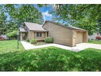 Charming single-story home features a one-car garage, manicured lawn, and mature trees at 4462 Carya Sq, Columbus, IN 47201