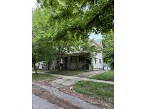 Charming two-story home with a classic design and covered front porch surrounded by mature trees at 48 N Audubon Rd, Indianapolis, IN 46219