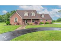 Charming brick home featuring a well-manicured lawn and a long, curved driveway at 505 Jones Pl, Martinsville, IN 46151