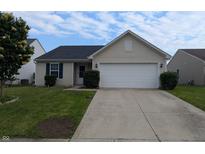 Charming single-story home featuring a two-car garage, manicured lawn, and inviting entryway at 581 Grassy Bend Dr, Greenwood, IN 46143