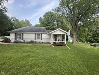 Charming single-story home featuring a cozy front porch, well-maintained lawn, and mature trees at 6691 N Baltimore Rd, Monrovia, IN 46157