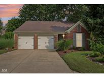 Charming single-story brick home featuring a two-car garage and well-maintained landscaping at 6760 Navigate Way, Indianapolis, IN 46250