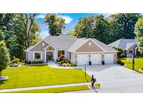 Aerial view of a home with a three-car garage, well-maintained lawn, and lush landscaping at 6940 Mockernut Ct, Plainfield, IN 46168
