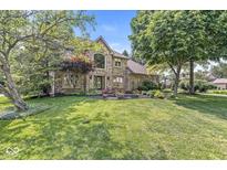 Charming two-story brick home with manicured lawn and lush landscaping at 8712 Admirals Bay Dr, Indianapolis, IN 46236