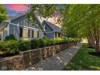Charming home with beautiful landscaping, stone retaining wall, and gray siding with black shutters at 900 W Busby St, Lebanon, IN 46052