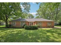 Charming brick home with a well-manicured lawn and mature trees, creating a welcoming curb appeal at 9014 Holliday Dr, Indianapolis, IN 46260