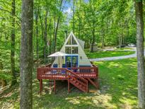 Charming A-frame home nestled among trees, featuring a spacious deck and bright blue door at 1413 N Lost Lake Rd, Columbus, IN 47201