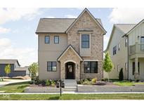 Charming two-story home featuring mixed brick and siding, professional landscaping and inviting entryway at 1655 Carrollton Rail Dr, Westfield, IN 46074