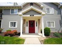 Inviting entrance to unit 207 with a red door and well-maintained landscaping at 207 Keats Ct # 102, Carmel, IN 46032