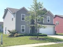Charming two-story home features a well-manicured front yard and classic vinyl siding at 2253 Jaybird Dr, Greenfield, IN 46140
