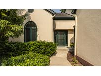 Charming home exterior with a green front door, arched window, and lush landscaping at 4428 Edinburgh Pt, Indianapolis, IN 46228