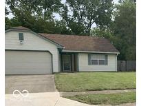 Traditional home featuring white siding, a brown roof, and an attached two-car garage at 4428 Tucson Dr, Indianapolis, IN 46241