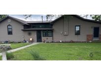 Quaint home featuring neutral siding and a metal roof, complemented by a well-maintained lawn and decorative accents at 4849 S 500 E, Greenfield, IN 46140