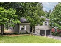 Charming exterior view with a two-car garage, dark roof, and well-maintained lawn at 5884 Compton St, Indianapolis, IN 46220