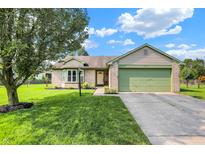 Charming single-story home with a well-maintained lawn, a two-car garage, and colorful landscaping at 6842 Sextant Dr, Indianapolis, IN 46260