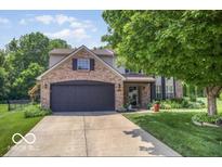 Charming two-story home with brick accents, mature trees, and a well-manicured lawn at 7211 Topp Creek Ct, Indianapolis, IN 46214