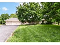 Charming brick home featuring a well-manicured lawn and mature trees enhancing its curb appeal at 7220 Normandy Way, Indianapolis, IN 46278