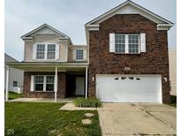 Charming two-story brick home featuring a covered front porch and a two-car garage at 832 Spinney Ln, Whiteland, IN 46184