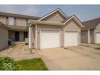 Inviting townhouse featuring attached two-car garage, neutral siding, and well-maintained landscaping at 8410 Hague Rd # 5, Indianapolis, IN 46256