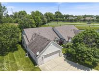 A stunning aerial view of a house featuring a brick exterior, lush landscaping, and a well-manicured lawn at 10934 Harness Ct, Indianapolis, IN 46239
