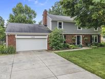 Charming two-story home featuring a brick and siding facade, attached two-car garage and beautiful landscaping at 11409 Haverstick Rd, Carmel, IN 46033
