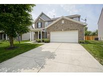 Charming two-story brick home featuring a two-car garage and well-manicured landscaping at 12382 Cool Winds Way, Fishers, IN 46037