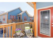 Cozy balcony view with outdoor seating, vibrant flowers, and colorful exterior finishes at 1635 N College Ave # 4, Indianapolis, IN 46202