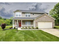 Charming two-story home featuring a covered front porch, red door, two-car garage, and a well-manicured lawn at 19187 Outer Bank Rd, Noblesville, IN 46062