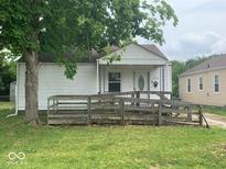 Charming single-story home with a covered front porch and a wooden access ramp at 1943 N Drexel Ave, Indianapolis, IN 46218